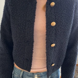 Mörkblå teddyjacka med guldknappar - Säljer en mörkblåteddyjacka med snygga guldknappar framtill. Jackan är såååå fin o inte använd ❤️
