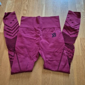 Vinröda seamless tights med mönster - Säljer ett par vinröda seamless tights från Better bodies med snygga detaljer längs benen och hög midja. Djur finns i hemmet.
