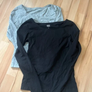 2-pack långärmade toppar från 157 - Säljer två långärmade toppar från 157 i storlek XS. En är svart och en är ljusgrå. Båda har rund halsringning och är tillverkade i mjuka material med stretch för en bekväm passform. 95% och 85% bomull. Båda för 25kr