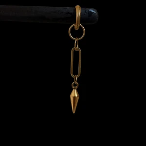 Guldigfärgade örhänge med detaljer - Coolt örhänge i guld med en lång kedja och en spetsig konformad detalj längst ner. Modern och edgy design som verkligen sticker ut. Perfekt för dig som vill ha något unikt och trendigt i smyckeslådan. Säljs styckvis. 
