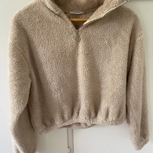 Beige teddyjacka från Chiquelle - Supermjuk och fluffig beige teddytröja från Chiquelle med halv dragkedja och hög krage. 