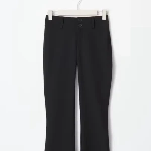 Svarta bootcut-byxor från Gina Tricot kostymbyxor   - Svarta bootcut-byxor från Gina Tricot med två knappar i midjan, bälteshällor och snygga fickor med lock och knapp bak. Byxorna har en klassisk look och är gjorda i ett mjukt bomullsmaterial med lite stretch för extra komfort. Petite! 