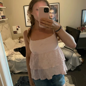 Ljusrosa volangig linnetopp - Supersöt ljusrosa linnetopp med smala axelband, har två små svarta defekter, vet inte om dom går att ta bort men toppen kommer inte till användning 😬🩷