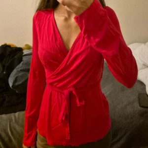 Röd omlott tröja - Säljer denna röda omlott tröjan. På bilden ser den orange ut, men i verkligheten är den röd. Köparen står för frakten! 