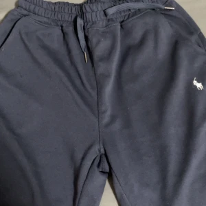 Mörkblåa shorts Polo Ralph Lauren XL - Mörkblå shorts från Polo Ralph Lauren i storlek XL. Byxorna har elastisk midja med dragsko, sidfickor och den klassiska broderade loggan på benet. Perfekta för chill dagar och snygg streetstil. Den är ganska liten i storlek hade passat L.