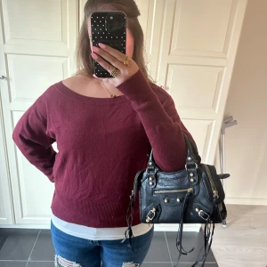 Vinröd stickad tröja  - Mysig vinröd stickad tröja från Bik Bok med bred halsringning och långa ärmar. Tröjan har ribbade muddar och en relaxed passform som är perfekt till jeans. Enkel och stilren design som funkar till många outfits.