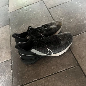 Nike Flyknit svarta sneakers - Svarta Nike sneakers med Flyknit-överdel och vit sula. Ett par sköna golfskor! 