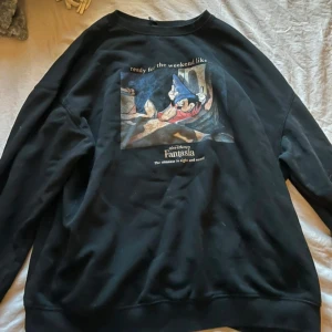 Svart Disney Fantasia sweatshirt - Cool svart sweatshirt med tryck av Mickey Mouse 'ready for the weekend like...'. Tröjan har rund hals och långa ärmar, perfekt för dig som gillar Disney och vill ha en avslappnad stil.