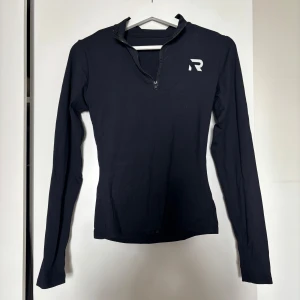 Svart långärmad träningströja Relode - Svart långärmad träningströja från Relode med halv dragkedja framtill och logga på bröstet. Tight passform och hög krage, perfekt för gymmet eller löprundan. Tillverkad i mjukt och stretchigt material som andas.