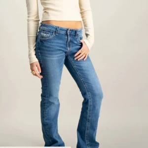 Blå bootcut jeans från Gina Tricot - Snygga blå jeans från Gina Tricot i bootcut-modell med låg midja. Jeansen har klassiska fem fickor, coola bakfickor. Jeansen är i storlek 170 och skulle säga att dem passar Xs