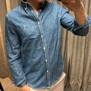 Jeansskjorta från Ralph Lauren  - Snygg jeansskjorta från Ralph Lauren i ett riktigt bra skick | Sitter som S | Killen på bilden är 173 cm lång!