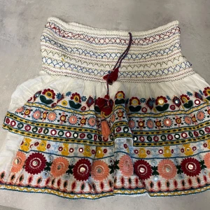 Broderad vit kortkjol med volang - Super fin kjol från Zara.Köpt på Vinted men jag har endast använt den ett få tal gånger då den är förstorför mig.den är lite lös i en av trådarna i resåren.Men det är inget som syns så tydligt.Jag är bortrest just nu men kommer hem om typ lite mer än en vecka.