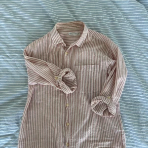 Skjorta - Säljer nu min riktigt snygga skjorta från zara. Skjortan är långärmad med möjlighet att knäppa fast ärmen så den blir kortare(se bild 3) skjortan är använd sparsamt och är så gott som ny. Hör av dig vid frågor och intresse! Färgen är vit och rosa.