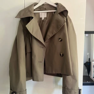 Beige croppad trenchcoat från H&M - Så fin grön trenchcoat från H&M. Aldrig använd, endast provad men utan lappen