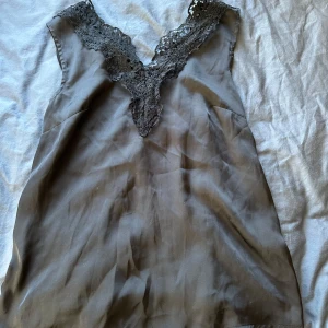 Svart spetslinnetopp från H&M  - Svart topp från hm med spets. Siden framtill och bomull bak. Storlek S. Skriv om bild med plagget på önskas. Pris kan diskuteras.