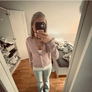 Ljusrosa kofta från H&M - Säljer en ljuslila kofta från H&M med knappar framtill, ser mer ut som ljusrosa och passar mycket mer som en s. Skriv om fler bilder, tryck gärna köp direkt 💕