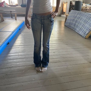 Blå bootcut jeans med detaljer - Nyskick, storlek 34. Hon på bilden är ca 165💕 (säljer två par liknadana) 