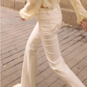 Vita jeans - Riktigt coola jeans, vita med bruna sömmar, lågmidjade och går hela vägen ner till marken på mig som är 175cm. Helt perfekta nu till sommaren!💕💕 ny pris 700kr