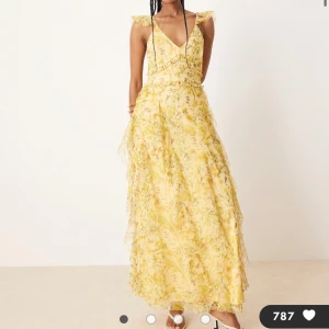 Lace and Beads Asos. Gul blommig långklänning med volanger - Lace and Beads klänning från Asos. Storlek 34, nypris 1249kr. Superfin långklänning i ljusgul ton med blommigt mönster och volangdetaljer. Djup v-ringning, ärmlös med volangaxlar och omlottkänsla upptill. Klänningen har flera lager i ett tunt, flowy material som ger en romantisk vibe.  Lappen kvar aldrig använd :) 