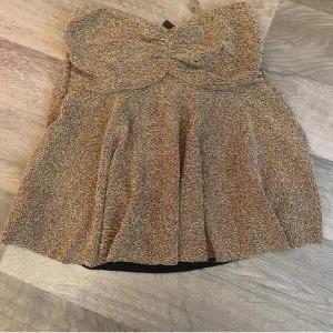 Glittrig guldig tubtopp från Missay - Supersnygg glittrig tubtopp i guld från Missay. Toppen har bandeau-modell med lätt rynkad byst. Verkligen så så fin! Den har prislappen kvar, kontakta för fler frågor💗