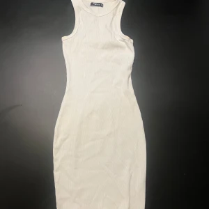 Vit ribbad kortklänning från Pieces - Supersnygg vit ribbad klänning från Pieces med tight passform och ärmlös design. Modellen är en klassisk kortklänning med rund halsringning och sportig rygg. Perfekt för dig som gillar en clean och enkel stil.
