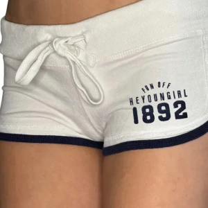 Vita shorts  - Superfräscha vita shorts med marinblå kant och tryck framtill. De har snörning i midjan. Inte så använda. Obs går ej ner i pris