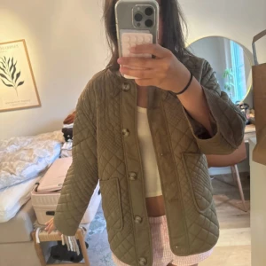 Olivgrön quiltad jacka med knappar - Ordinarie pris 1000kr.🌸🌸Quiltad jacka i olivgrönt med stora fickor framtill och knäppning med knappar. Jackan har lång ärm och en loose passform, perfekt för lager-på-lager. Snyggt rutmönster över hela jackan ger en trendig vibe.