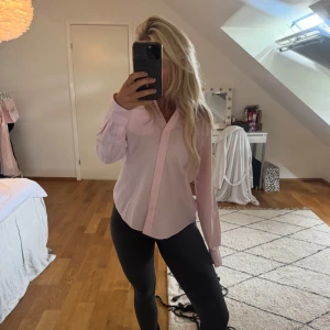 Gant skjorta dam  - Säljer en klassisk ljusrosa skjorta med lång ärm och bröstficka. Skjortan har knappar hela vägen fram och en stilren krage. Perfekt för en enkel sommarlook. Har tydligen några gula fläckar som jag själv inte sett. 