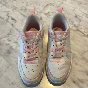 Pastellfärgade sneakers med snörning - Snygga sneakers i vitt med pastellfärgade detaljer i rosa, blått och gult. Skorna har snörning, rund tå och platt sula. Perfekta för dig som gillar färg och vill sticka ut lite extra. Materialet är syntet och textil, och de har en fräsch, modern vibe.