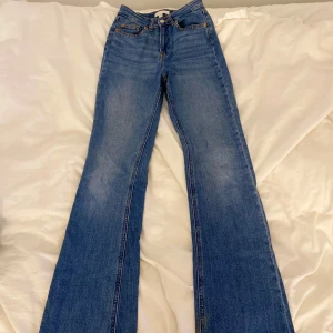 Blå bootcut jeans från H&M, stl 34 - Snygga blå bootcut jeans från H&M i storlek 34. Jeansen har klassisk femficksdesign, hög midja och är tillverkade i bomull. De är i modeller bootcut. De är lite slitna längst ner men det syns inte eftersom det är längst ner på benet. Priset kan diskuteras!