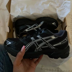 Asics gel 1130 svart silver y2k - Snygga och bekväma skor! Alldeles nya, endast använda en kort stund utomhus då jag märkte att det tyvärr är lite för tighta på mig som ligger emellan storlek 38 och 39. Köpte för att ha under tågluff! Åker tyvärr om två dagar så köp gärna innan det så jag hinner skicka ifall du är intresserad!😊