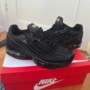 Nike Air Max Plus TN helsvarta sneakers - Nike Air Max Plus TN i helsvart med ikoniska TN-detaljer på plösen och hälen. Snygg design med mesh och syntetpaneler, synlig Air Max-dämpning och robust sula. Perfekta för dig som vill ha en clean och sportig look med maxad komfort.