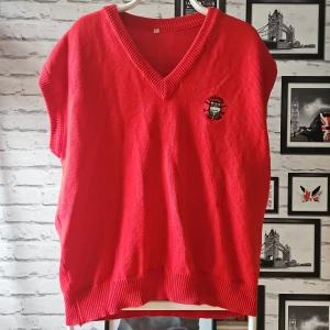 Röd stickad väst - Röd stickad väst med broderad Stralfors Golf Team-logga på bröstet. Västen har v-ringning, ribbade kanter. Perfekt för dig som gillar sportig och klassisk stil.