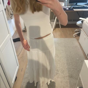 Vit långkjol  - Superfin vit långkjol från Stradivarius i luftig bomull. Kjolen har flera volanger och ett lätt rynkat modjeband. Perfekt för varma dagar speciellt nu på sommaren ☀️💙! Nypris idag är 329 och säljer för 200 som startbud💕