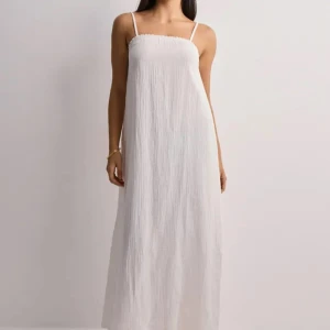 Vit långklänning  - Superfin vit långklänning från Vero Moda med tunna axelband och lätt rynkad överdel. Slutsåld. Klänningen är i 100%  bomull med en luftig känsla, perfekt för varma dagar. Enkel och stilren design som ger en chill vibe. Oanvänd med lappen kvar🤍