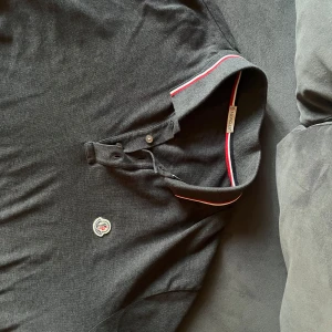Mörkgrå Moncler pikétröja långärmad - Snygg mörkgrå långärmad pikétröja från Moncler. Inprincip oanvänd, väldigt bra skick. Storlek XXL men passar XL. Priset kan diskuteras.