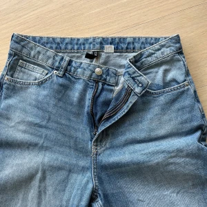 Jeans - Säljer ett par blå jeans från Divided med raka ben och slitna detaljer på båda knäna. Säljer då dom är för små för mig. Skriv vid frågor💕💕