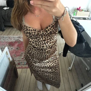 Leopardmönstrad långklänning - Snygg långklänning med leopardmönster och smala axelband. Klänningen har en figurnära passform och ärmlös design, perfekt för dig som vill sticka ut. Materialet känns mjukt och följsamt mot kroppen.