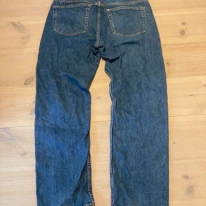 Blå raka jeansbyxor - Klassiska blå jeansbyxor med raka ben och femficksdesign. Byxorna har normal passform och stängs med dragkedja och knapp. Perfekta för en avslappnad stil och passar till det mesta. Skicka ett meddelande för frågor, storlek, mått osv. 