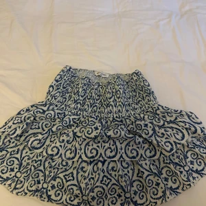 Blåvit mönstrad kjol från Meet me there - Supersöt blåvit kjol från Meet me there med volanger och elastisk midja. Jag som vanligt viss jag xs/s tycker att den passar super bra men den kommer inte till användning tyvärr🫰🏽kjolen är som ny och köpt för 390kr!!!! Kjolen är köpt från meet me there men heter meet x tiger.🩷🩷