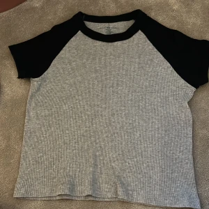 Grå och svart t-shirt från Brandy Melville  - Säljer den populära blå/gråa ribbade T-shirten från Brandy Melville💞one size🌸köparen står för frakten 💞pris kan diskuteras 🩷