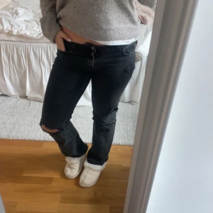 Unika low jeans med hål  - Säljer ett par svarta jeans som är bootcut men lite åt det rakare hållet. Jag har gjort hålen själv så de är väldigt unika. Det finns slitningar på ena knät, vid bakfickan och lite vid framfickorna. Även ett hål på vänster knä. Jeansen är köpta från hm❤️