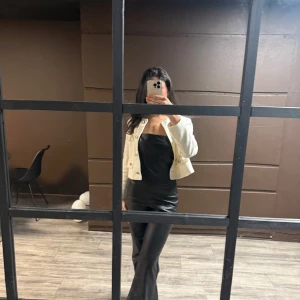 Svart långklänning med smala axelband - söljer en svart overall i läder som kommer utan armar, den är från zara i storlek 38