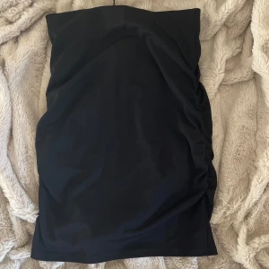 Svart kjol från BikBok - Säljer en svart,  tajt kjol från BikBok i storlek XS. Klänningen har en tight passform och lätt rynkade detaljer på sidan. Perfekt för dig som gillar en enkel och stilren look. Mer bilder på kan man få privat, den köptes typ 2022 så jag minns inte exakt priset! 🫰💞😸😽