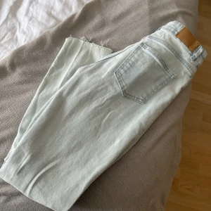 Ljusblå jeansbyxor från only - Säljer ett par ljusblå jeansbyxor från Gina Tricot med råa benslut och klassisk femficksdesign. Byxorna har hög midja och raka ben, perfekta för en avslappnad stil.