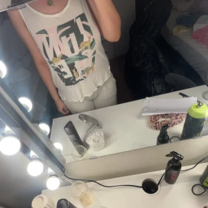 Vit croppad linnetopp med tryck - Säljer en vit croppad linnetopp med färgglatt tryck av djungel och leoparder. Toppen är ärmlös och har en avslappnad passform, perfekt för varma dagar.