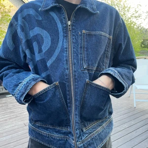 Mörkblå jeansjacka från Stüssy Workgear - Stussy SS-link zip up work jacket. Använd fåtal gånger och i fint skick! Skriv ifall du undrar nåt om jackan.🖋️