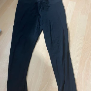 Svarta leggings från H&M - Svarta leggings från H&M i stretchigt material. Perfekta för en enkel och bekväm stil. Hög midja och smal passform som sitter snyggt längs benen.