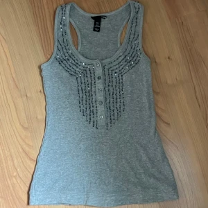 grått linne med pärlor - grått linne med gråa knappar och blå pärlor och paljetter .