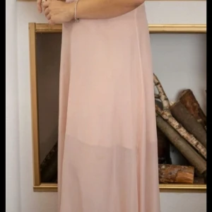 Långklänning med spetsliv och rosa kjol - Säljer en elegant långklänning med vitt spetsliv och ljusrosa, flowy kjol. 